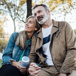husband and wife drinking coffee in park